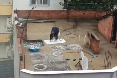 Yağmurlu havada çatıda halı yıkadı, görenler şaştı kaldı