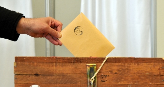 Bir el tuttuğu oy pusulasını sandığa atıyor