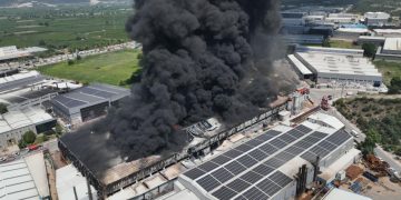 Yanan fabrikanın çatısından siyah dumanlar yükseliyor