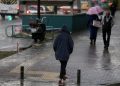 Bir kadın şemsiyesi ile yolda yürüyor hemen önünde bir erkek bulunuyor. Kadın ile erkeğin tam karşısında bir genç kadın yürümekte