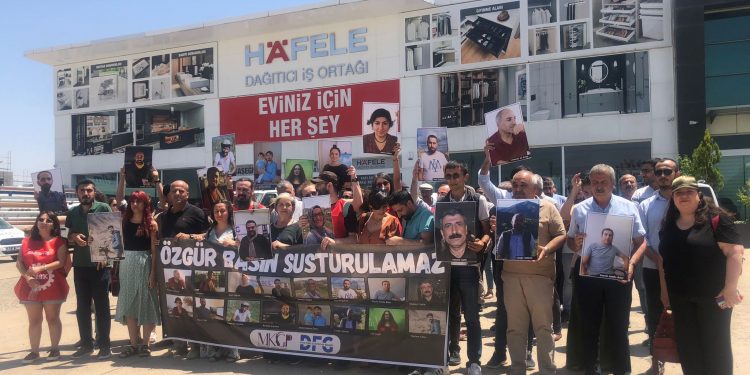 Diyarbakır'da gazeteciler önlerinde "Özgür basın susturulamaz" yazılı pankart taşıyorlar. Pankartta tutuklanan 16 gazetecinin fotoğrafları mevcut