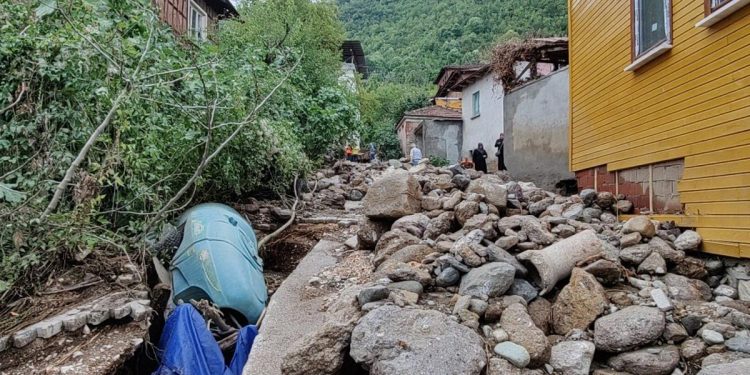 Sel nedeniyle sürüklenen taşlar evlerin yanındaki yolu kapatmış