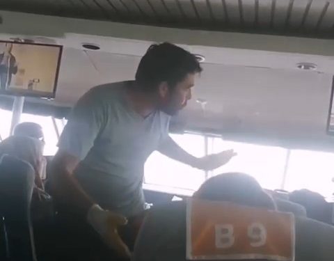 Deniz otobüsü içinde işçi eldivenli bir kişi ayakta duruyor