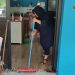 Mavi kıyafetli bir kadın, kafenin içinden çekpasla su çıkarıyor