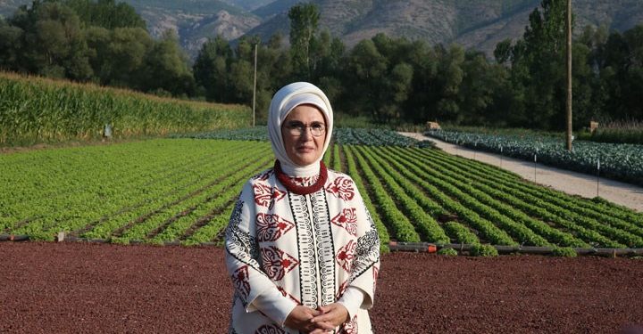 Emine Erdoğan arkasına tarım arazilerini almış şekilde poz veriyor.