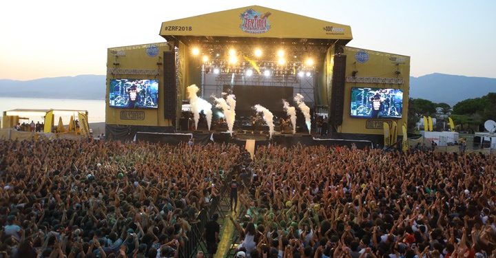Binlerce insan üzerinde Zeytinli Rock Festivali yazan sahnenin önünde elleri havada konseri dinliyor