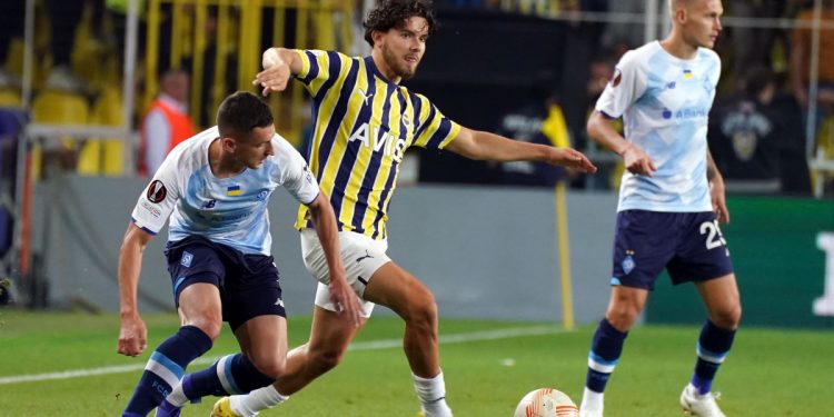 İki futbolcu arasında top kapmaya çalışan Fenerbahçeli bir oyuncu