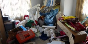 Evin odasında çekilen görüntüde eşyalar birbirinin üstüne yığılmış şekilde duruyor