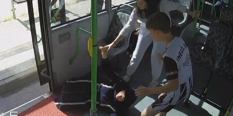 Otobüs içinde yerde yatan bir kadın ve başında bekleyen iki kişi var