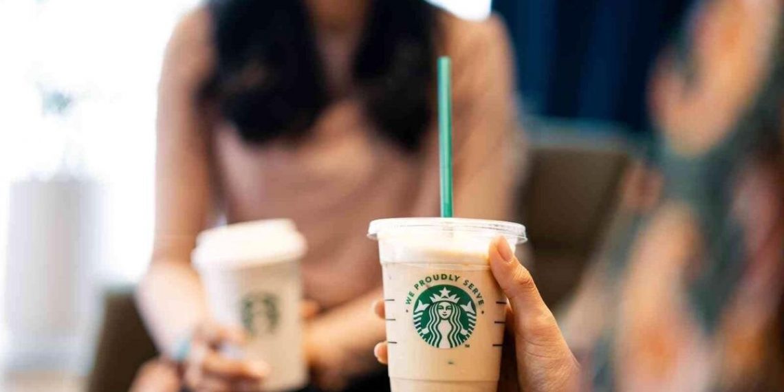 Karşılıklı oturan iki kişinin elinde kahve bardağı bulunuyor.