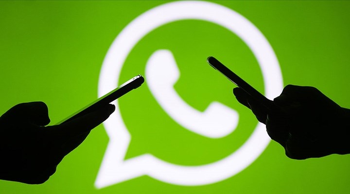 Yeşil renkli WhatsApp logosunun önünde iki tane silüet şeklindeki el telefon tutuyor