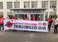 "Zorunlu emeklilik anayasaya aykırıdır, zorunlu emekliliğe hayır" pankartı arkasında duran sekiz kişi eylem yapıyor.