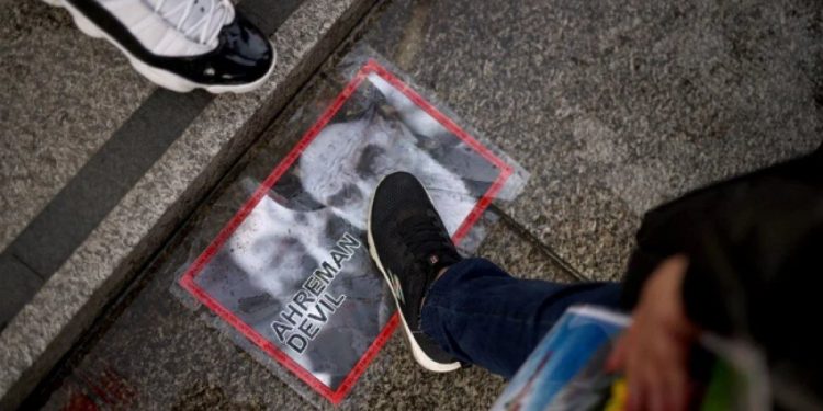 Protestolarda çekilmiş bir fotoğraf karesi.Ayetullah Ali Hamaney'in fotoğrafı ayaklar altında...