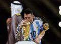 Messi, ödülünü elinde tutarken, Dünya Kupası'nı öpüyor.