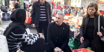 Nihat Yeşiltaş ve CHP ilçe yöneticileri bir pazar tezgahı önünde esnafı dinliyor.