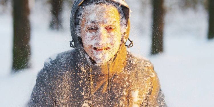 Soğuk havayı temsil eden bir görsel. Yüzü karla kaplı,montlu,üşüyen kadın fotoğrafı