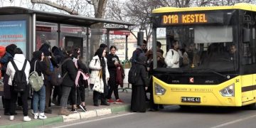 Otobüs durağında bekleyen öğrenciler sarı renkli otobüse sırayla biniyor.