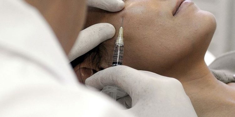 Bir kadına Kadına estetik operasyon uygulaması yapılıyor
